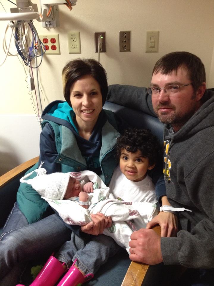 Adoptive parents and older sibling with new baby.