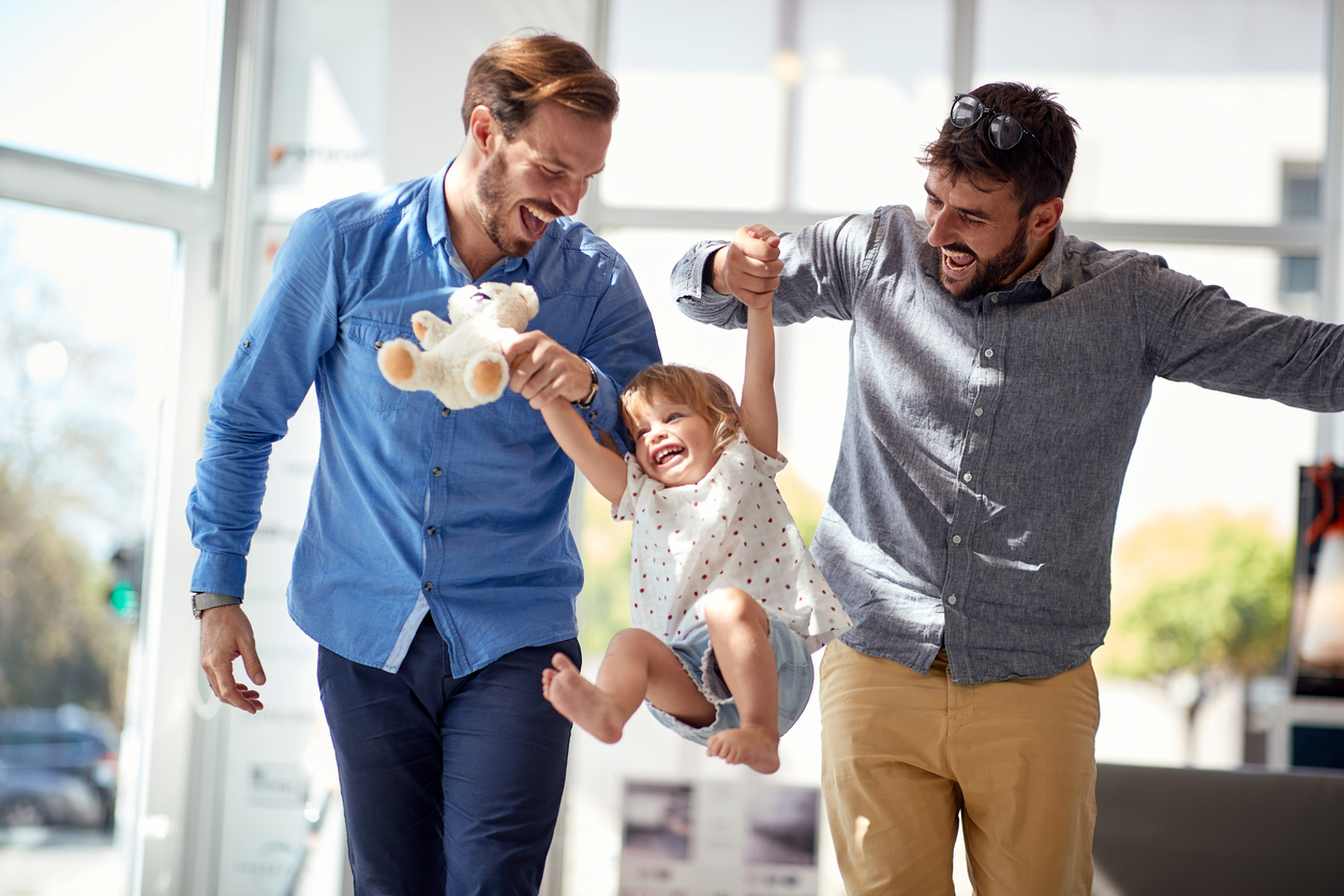 Men swinging child