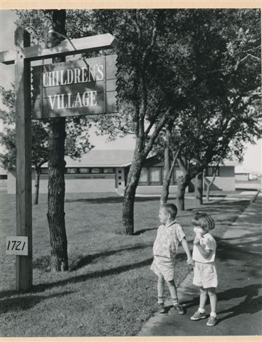Children outside the North Dakota Children Home sign