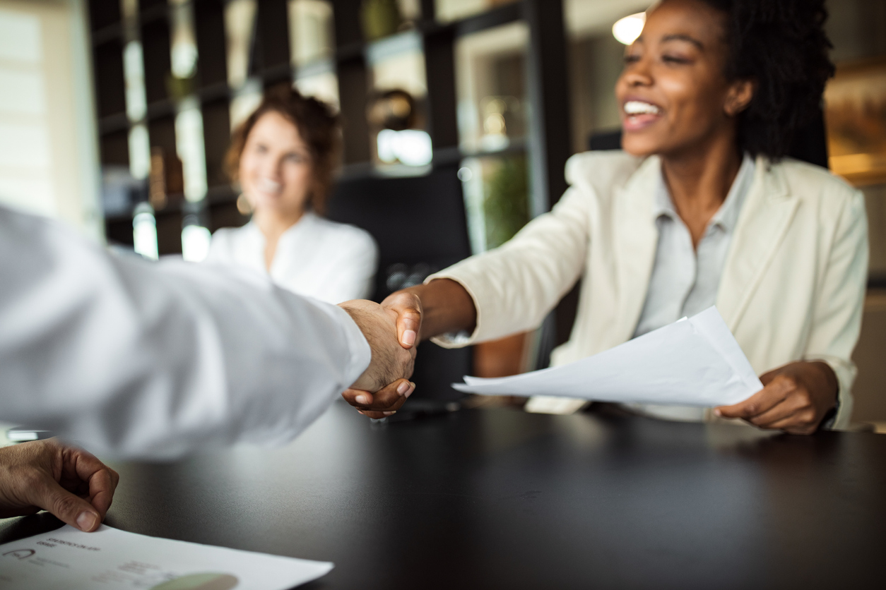 Businesspeople shaking hands across table