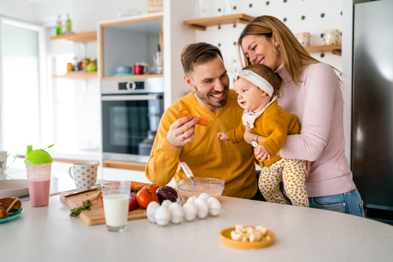 Mom, dad and baby in the family kitchen
