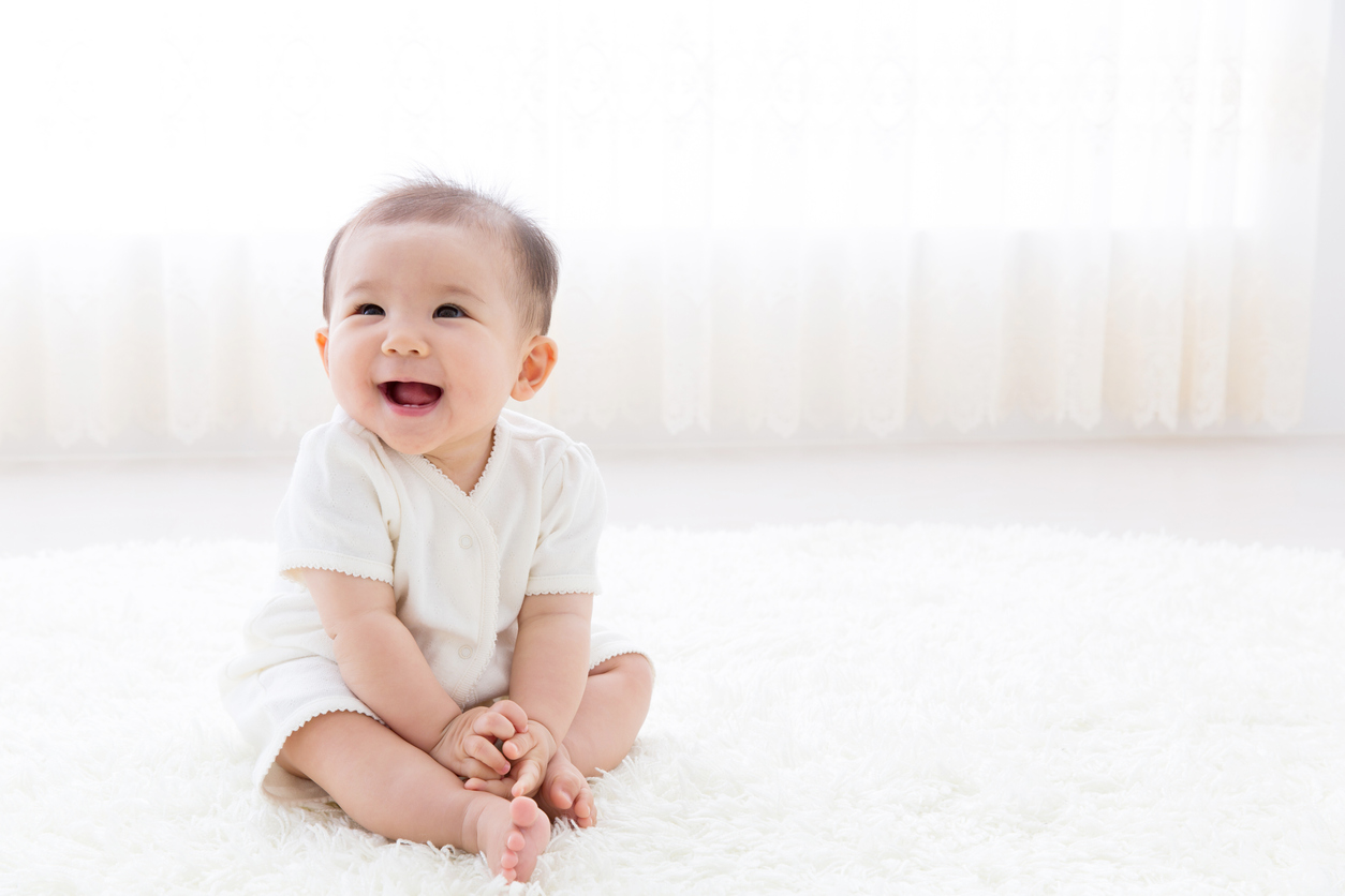 Baby sitting upright and smiling