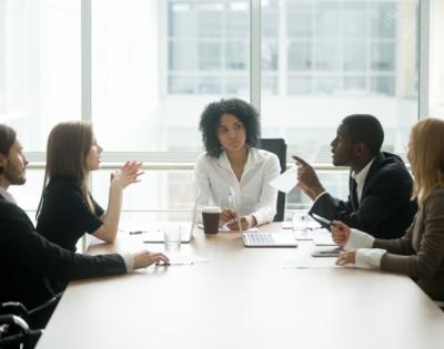 group of coworkers sitting around conference table talking