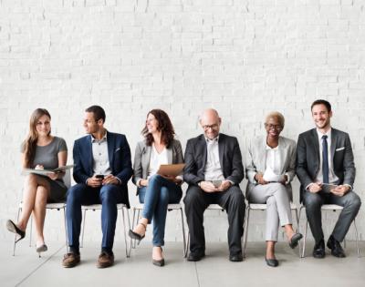 Diverse group of coworkers sitting in chairs in a line with each other