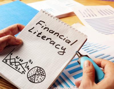 Financial Literacy handwritten on notebook with charts drawn below