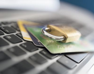 Lock and credit cards laying on top of computer keyboard