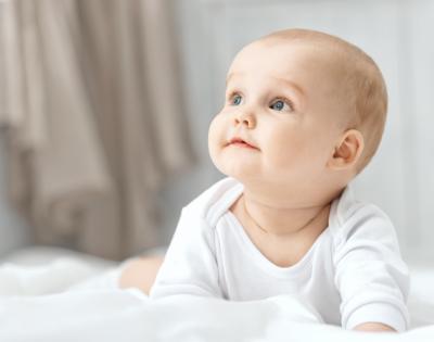 baby wearing white looking to side