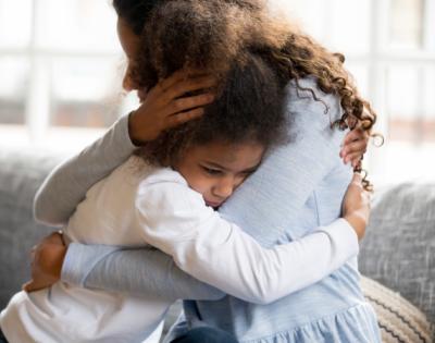 child with anxiety hugging mom