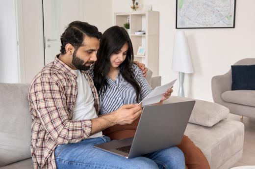 Couple sitting on couch review their credit report