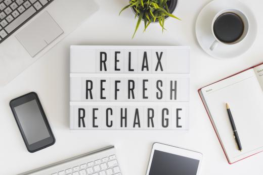 A letter sign is surrounded by electronic devices and reads Relax Refresh Recharge
