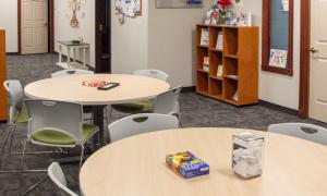 First Step Recovery's space with bookshelves, resources, tables and chairs