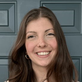 Headshot of Emma Hildebrandt, a white woman with dark brown, long hair