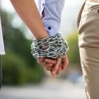 Couple's hands tied with metal chain