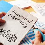 Financial Literacy handwritten on notebook with charts drawn below