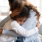 child with anxiety hugging mom