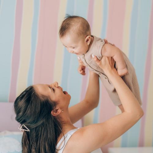 Woman holds baby up in the air