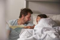 Father reads his daughter a bedtime story