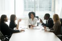group of coworkers sitting around conference table talking
