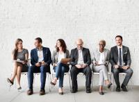 Diverse group of coworkers sitting in chairs in a line with each other