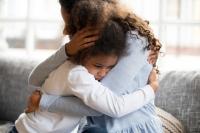 child with anxiety hugging mom