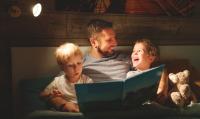 Dad reading a bedtime story to children before bed